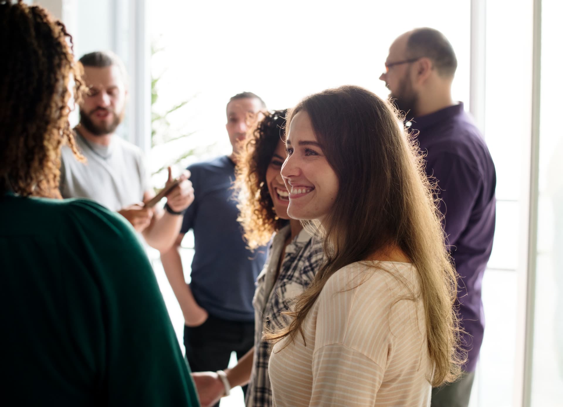 Mulher sorrindo numa roda de conversa com outros membros